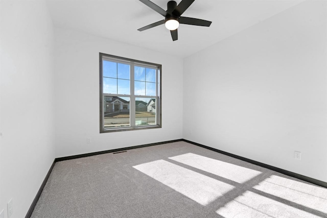 carpeted spare room with ceiling fan