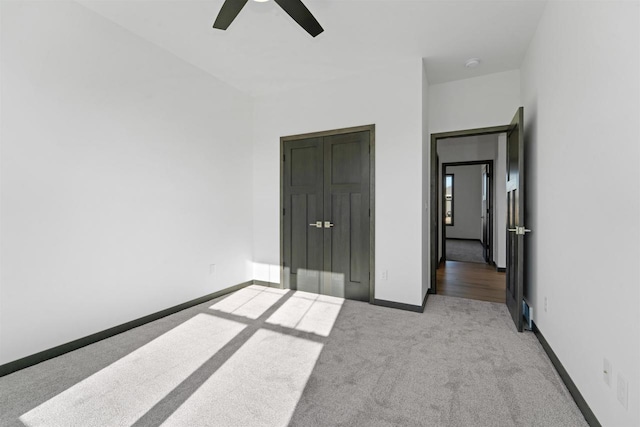 unfurnished bedroom featuring light colored carpet and ceiling fan