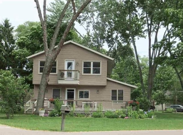 rear view of property with a wooden deck and a lawn