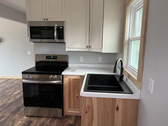 kitchen featuring white cabinetry, sink, dark wood-type flooring, and appliances with stainless steel finishes