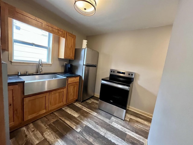 kitchen featuring appliances with stainless steel finishes, dark hardwood / wood-style flooring, and sink