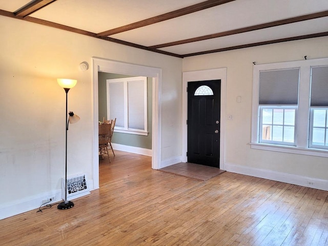 foyer featuring beam ceiling and light wood-type flooring