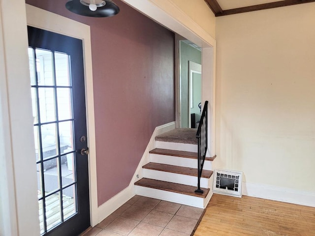 stairway featuring ornamental molding, heating unit, and tile patterned floors