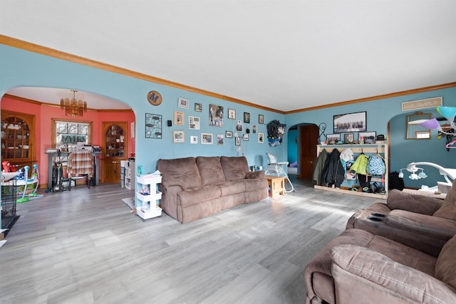 living room featuring hardwood / wood-style flooring, crown molding, and a chandelier