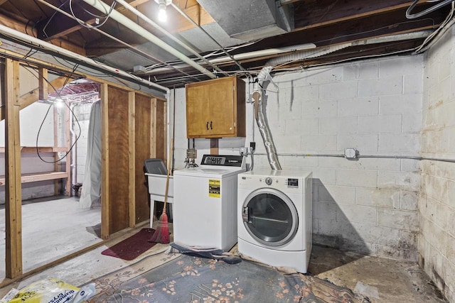 clothes washing area with cabinets and washing machine and dryer