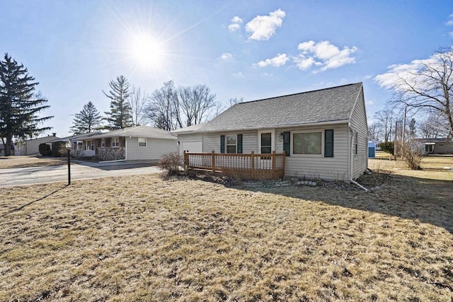 view of front of house with a deck and a front lawn