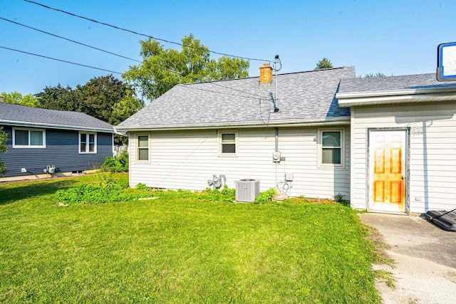 rear view of house featuring a yard and central air condition unit