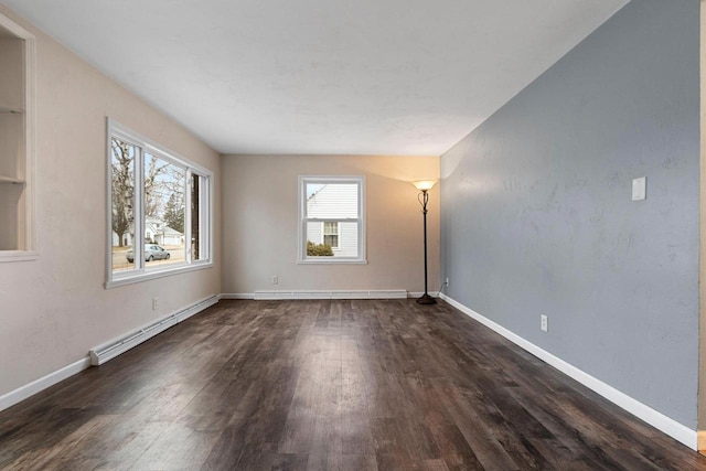 empty room featuring a baseboard heating unit and dark hardwood / wood-style floors