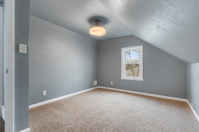 bonus room with vaulted ceiling, carpet flooring, and a textured ceiling