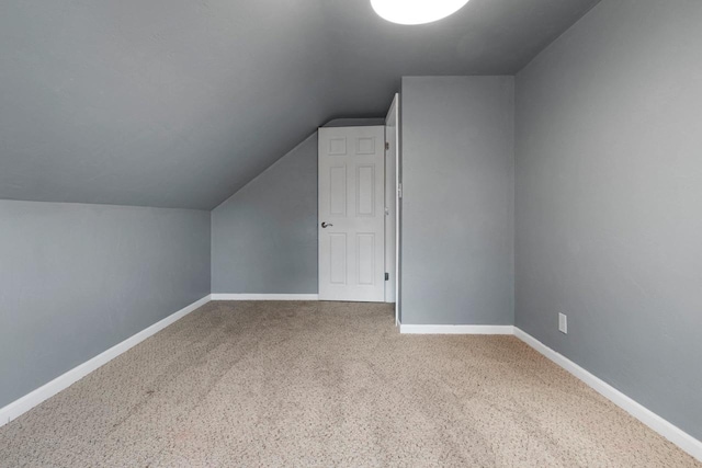 additional living space with carpet flooring and vaulted ceiling