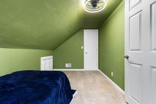 bedroom featuring vaulted ceiling, a textured ceiling, and carpet