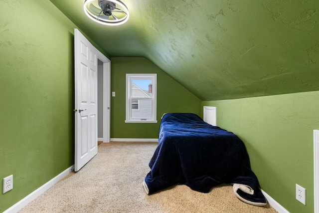 carpeted bedroom with vaulted ceiling