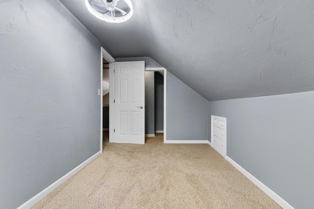 bonus room featuring carpet flooring, vaulted ceiling, and a textured ceiling