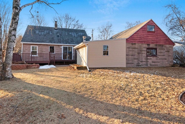 rear view of property featuring a wooden deck and a lawn