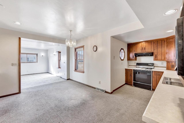 kitchen with pendant lighting, a chandelier, light carpet, and white range with gas stovetop