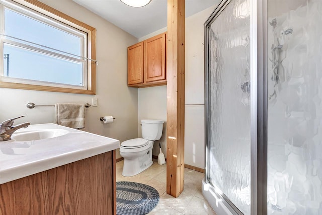 bathroom featuring a shower with door, vanity, tile patterned floors, and toilet