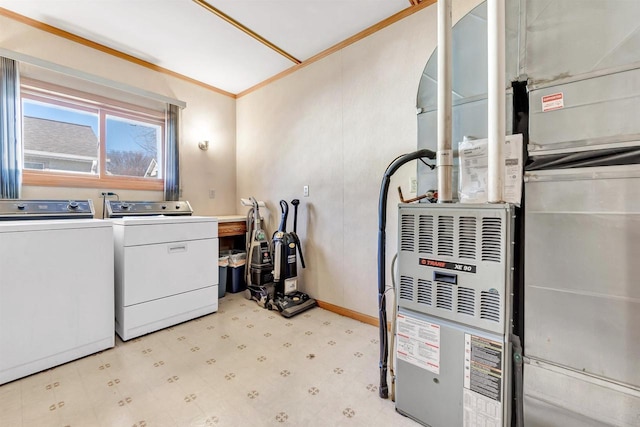 clothes washing area with heating unit, ornamental molding, and washing machine and dryer