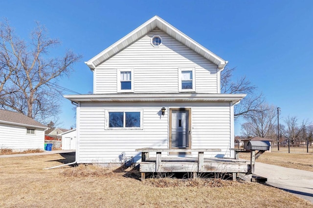 rear view of property with a wooden deck and a lawn