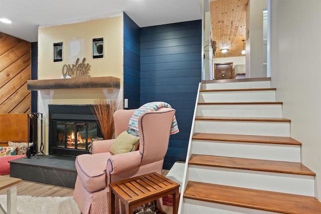 865 Richmond Way, Nekoosa, WI 54457 - staircase with wood finished floors, a glass covered fireplace, wood walls, and recessed lighting