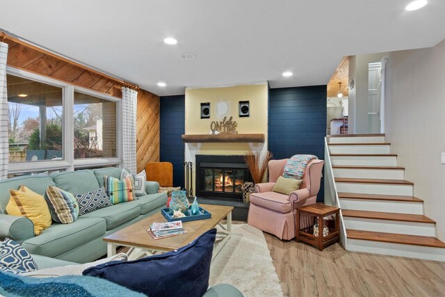 865 Richmond Way, Nekoosa, WI 54457 - living area featuring wood finished floors, wood walls, a glass covered fireplace, recessed lighting, and stairs