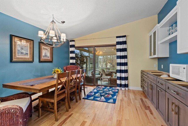 865 Richmond Way, Nekoosa, WI 54457 - dining space with a chandelier, lofted ceiling, light wood-style flooring, and baseboards