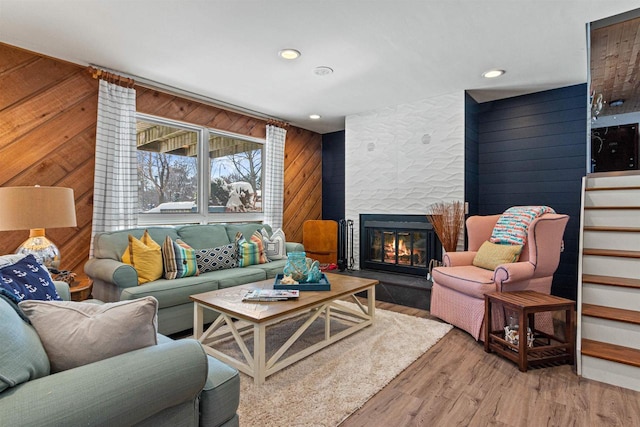 865 Richmond Way, Nekoosa, WI 54457 - living room featuring wood walls, a glass covered fireplace, light wood-style floors, recessed lighting, and stairs