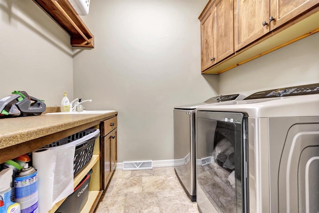 laundry area featuring cabinets, sink, and independent washer and dryer