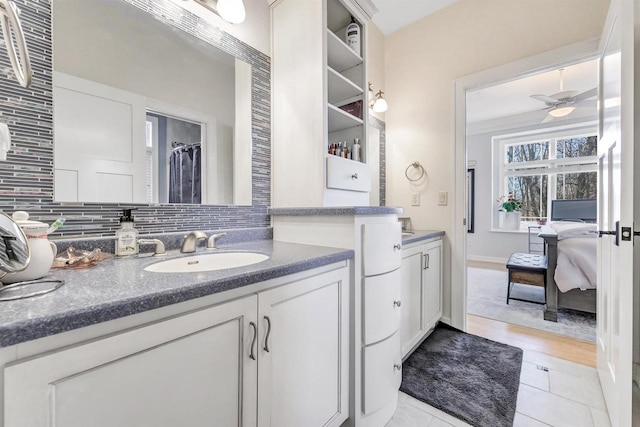 bathroom featuring vanity, decorative backsplash, and ceiling fan