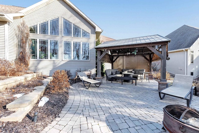 back of house with a gazebo, an outdoor living space with a fire pit, and a patio