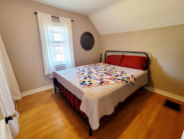 bedroom with lofted ceiling and light hardwood / wood-style flooring