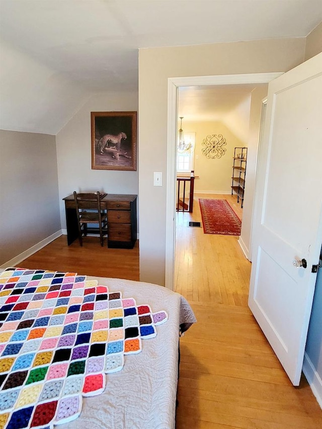 bedroom with lofted ceiling and hardwood / wood-style flooring