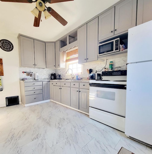 kitchen with white appliances, sink, decorative backsplash, and gray cabinetry