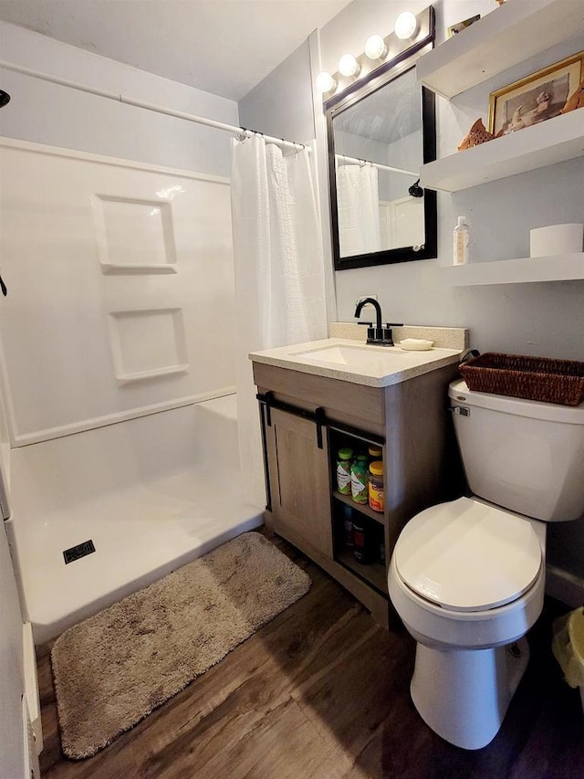 bathroom featuring hardwood / wood-style flooring, vanity, curtained shower, and toilet