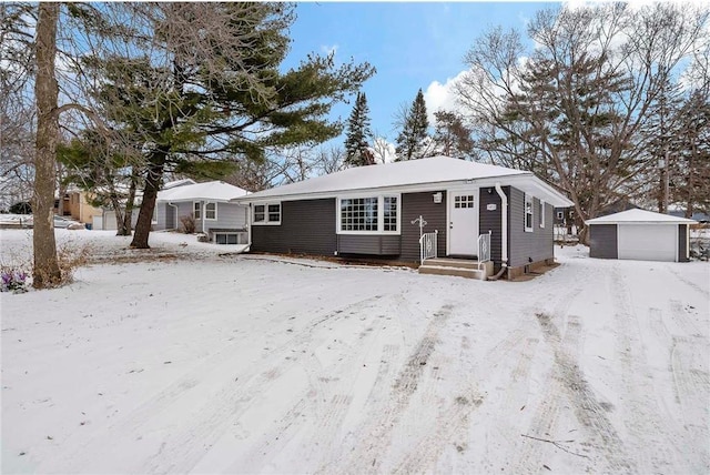 ranch-style home with a garage and an outbuilding