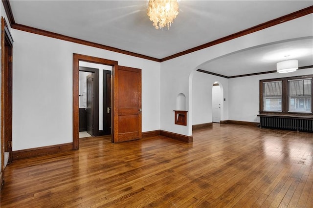 unfurnished living room with hardwood / wood-style flooring, ornamental molding, radiator, and a notable chandelier