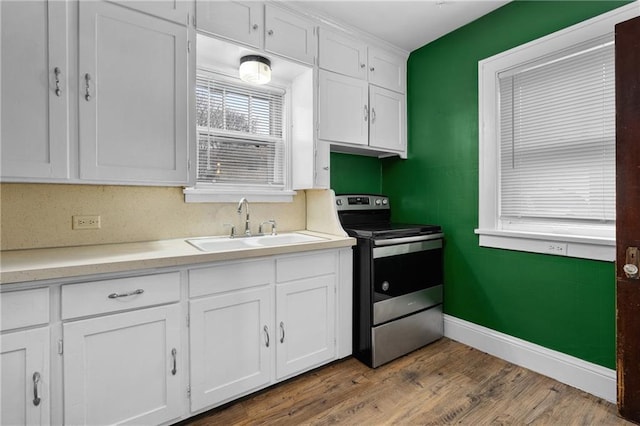 kitchen featuring white cabinetry, sink, hardwood / wood-style flooring, and stainless steel range with electric cooktop