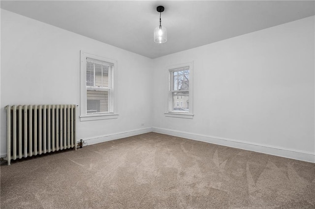 spare room with carpet floors and radiator heating unit