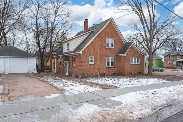 snow covered property with a garage and an outdoor structure