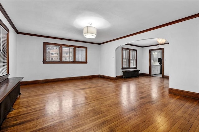 unfurnished living room featuring crown molding and dark hardwood / wood-style floors