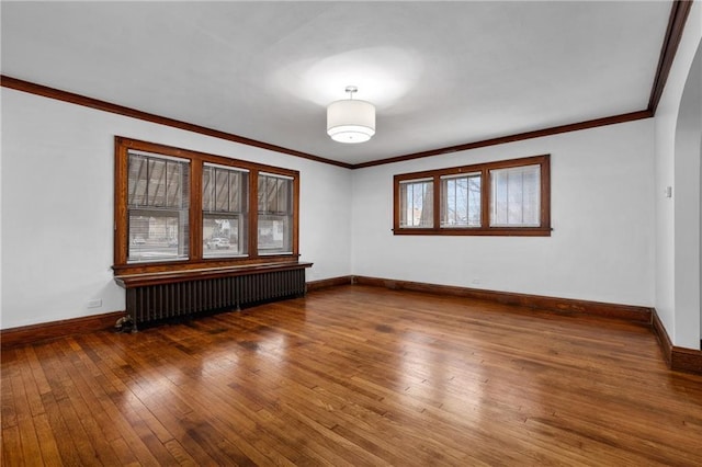 unfurnished room with hardwood / wood-style floors, ornamental molding, and radiator heating unit