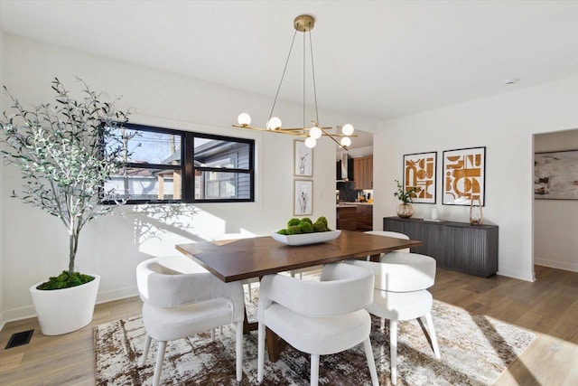 dining area featuring wood-type flooring and a chandelier