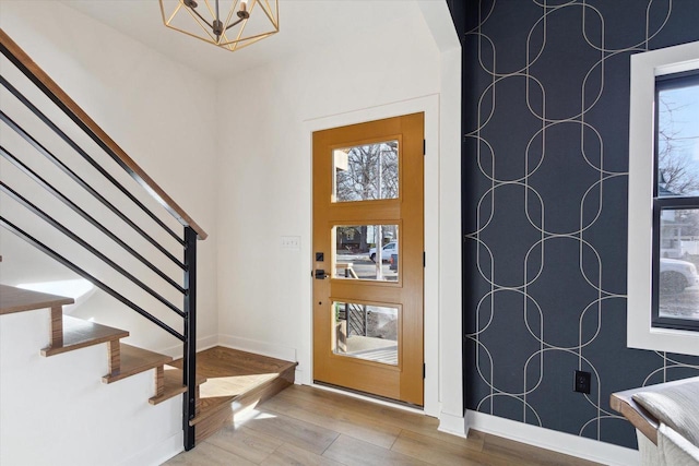 entrance foyer with hardwood / wood-style floors and a chandelier