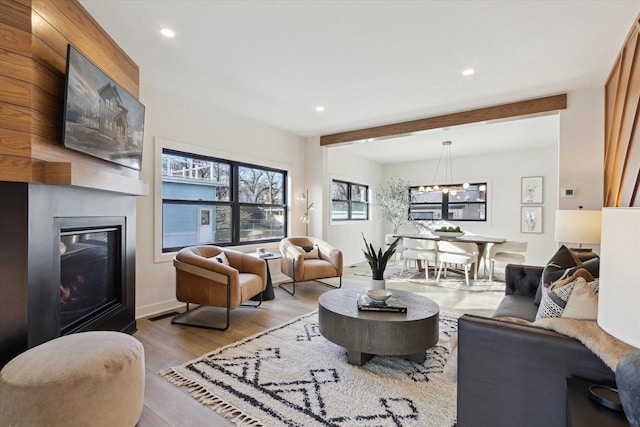 living room featuring beamed ceiling and light wood-type flooring