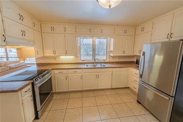 kitchen with white cabinetry, appliances with stainless steel finishes, sink, and light tile patterned floors