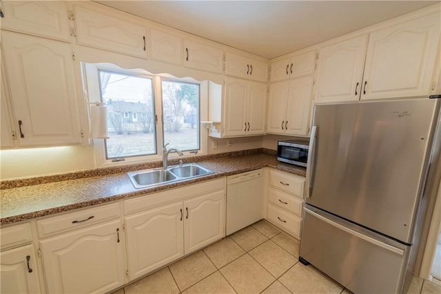 kitchen with stainless steel appliances, white cabinetry, sink, and light tile patterned flooring