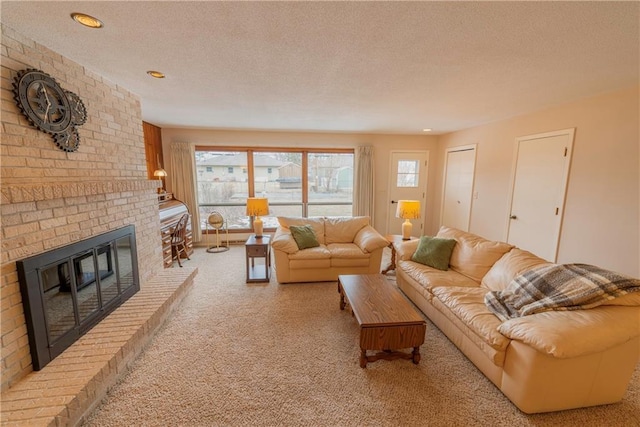 living room with a brick fireplace, light colored carpet, and a textured ceiling