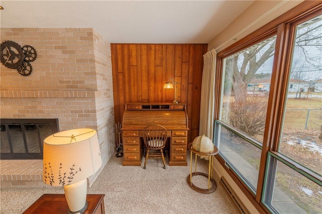 interior space with wooden walls, a fireplace, and light carpet