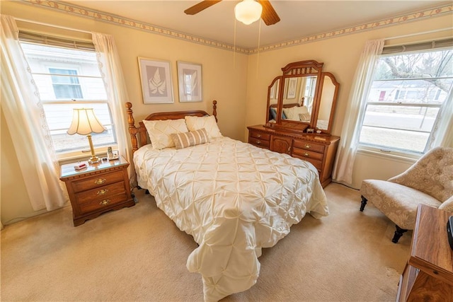 bedroom with ceiling fan and light carpet