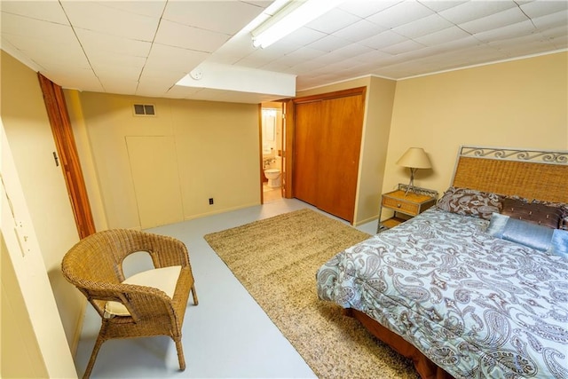 bedroom featuring a paneled ceiling and ensuite bath