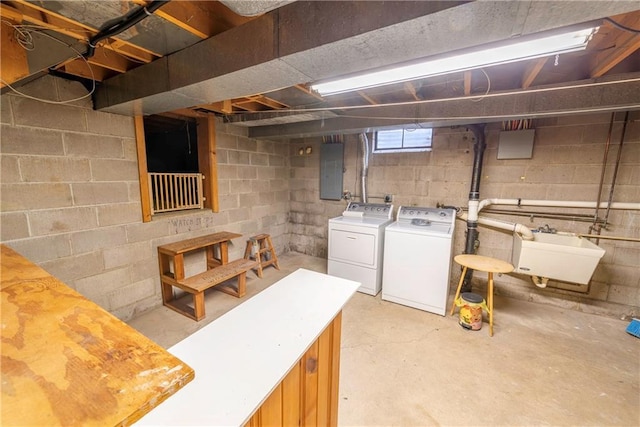 basement with washing machine and dryer, sink, and electric panel